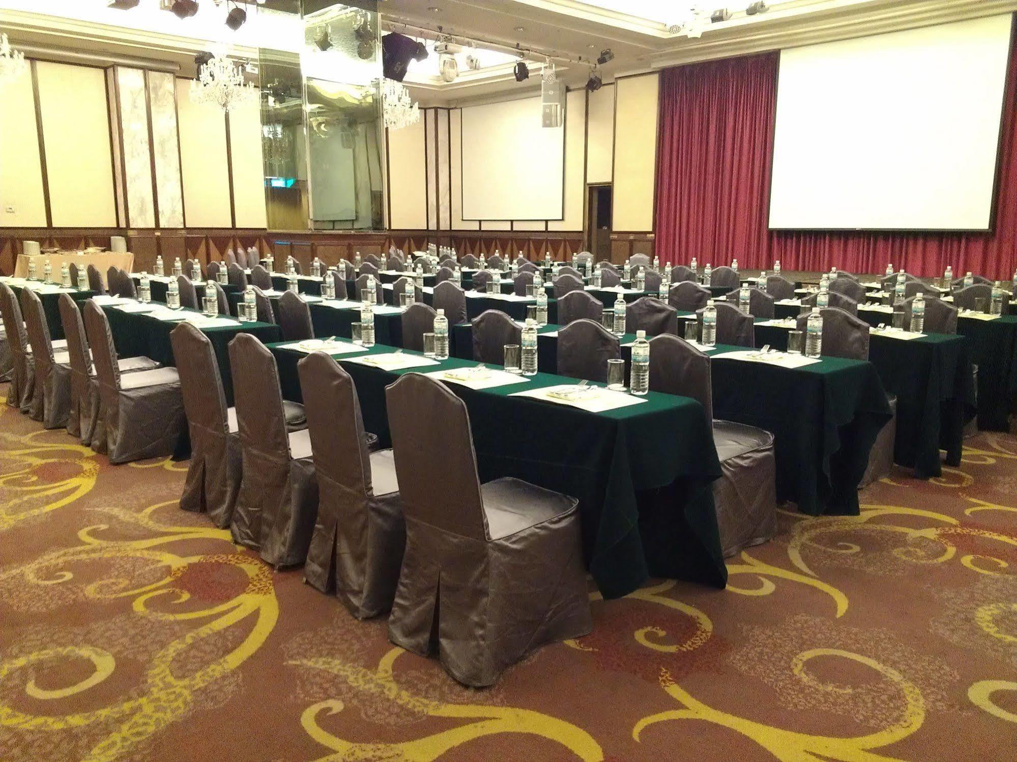 Evergreen Laurel Hotel - טאיצ'ונג מראה חיצוני תמונה The photo shows a large conference or meeting room set up with multiple tables arranged in a structured manner. Each table is covered with a tablecloth, alternating between black and green. There are chairs around each table, and each place setting a