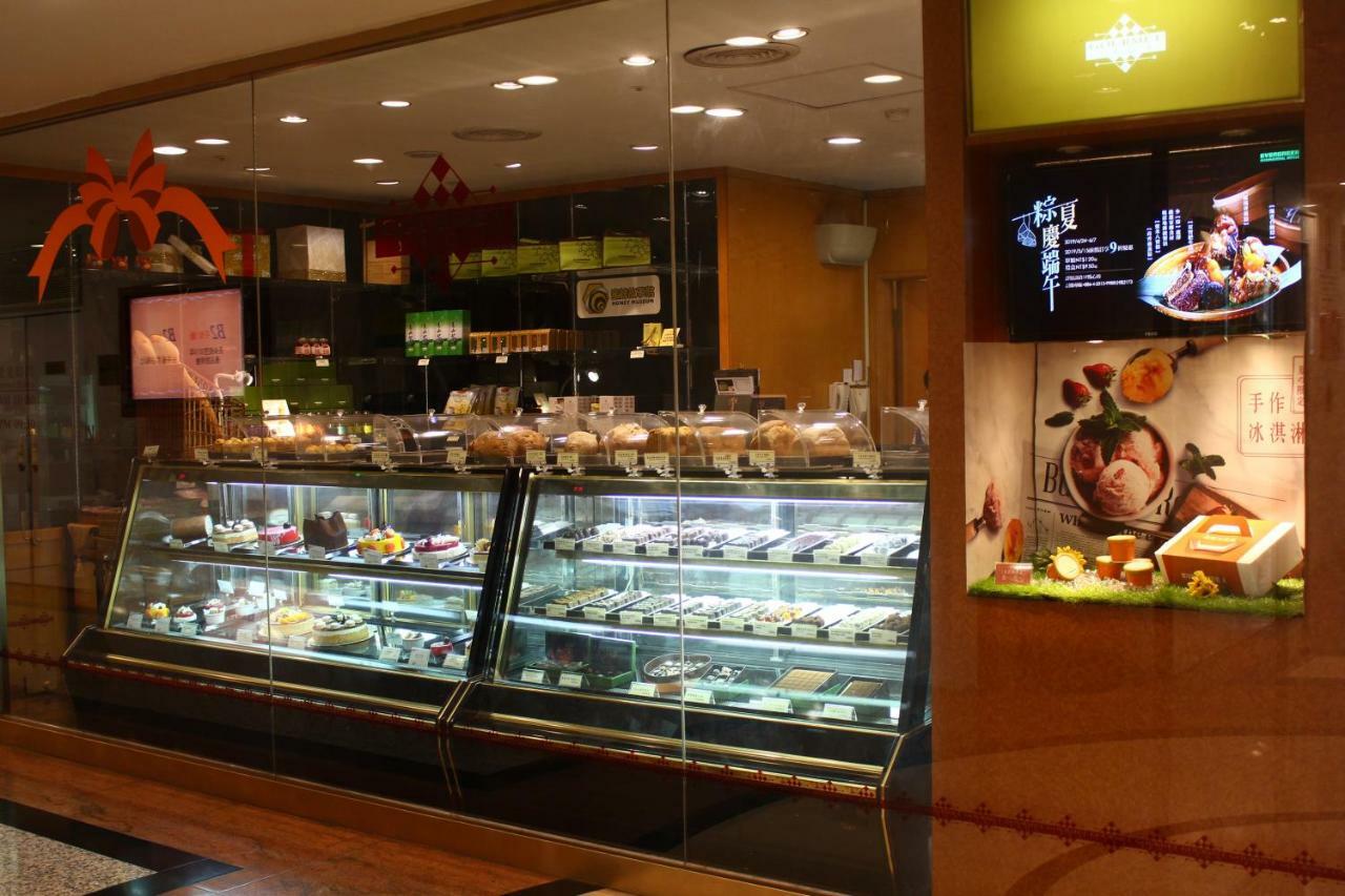 Evergreen Laurel Hotel - טאיצ'ונג מראה חיצוני תמונה The photo shows a display case in a bakery or dessert shop. The glass case is filled with a variety of pastries, cakes, and desserts arranged neatly. Behind the display, there is a counter with additional items and desserts visible. The walls are dec