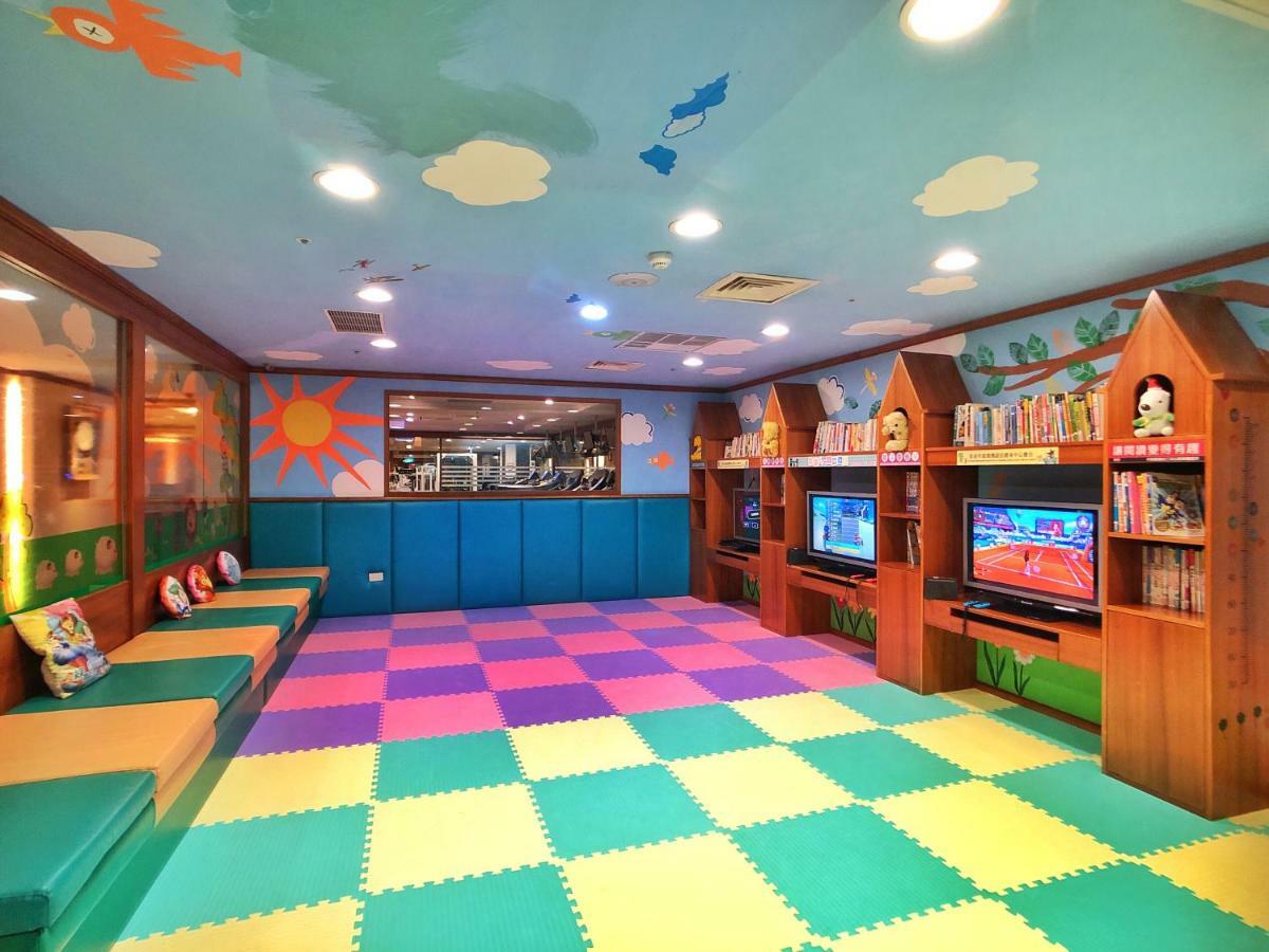 Evergreen Laurel Hotel - טאיצ'ונג מראה חיצוני תמונה The photo shows a brightly colored children's playroom or activity area. The floor is covered with large colorful tiles in shades of blue, green, yellow, and pink, creating a playful pattern. The walls have cheerful decorations, including sun and clo