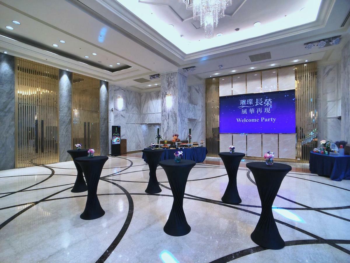 Evergreen Laurel Hotel - טאיצ'ונג מראה חיצוני תמונה The photo depicts a spacious and elegantly decorated event space, likely set up for a welcome party. The room features polished marble flooring and tall ceilings, giving it a sophisticated atmosphere. In the center, several round tables with black ta