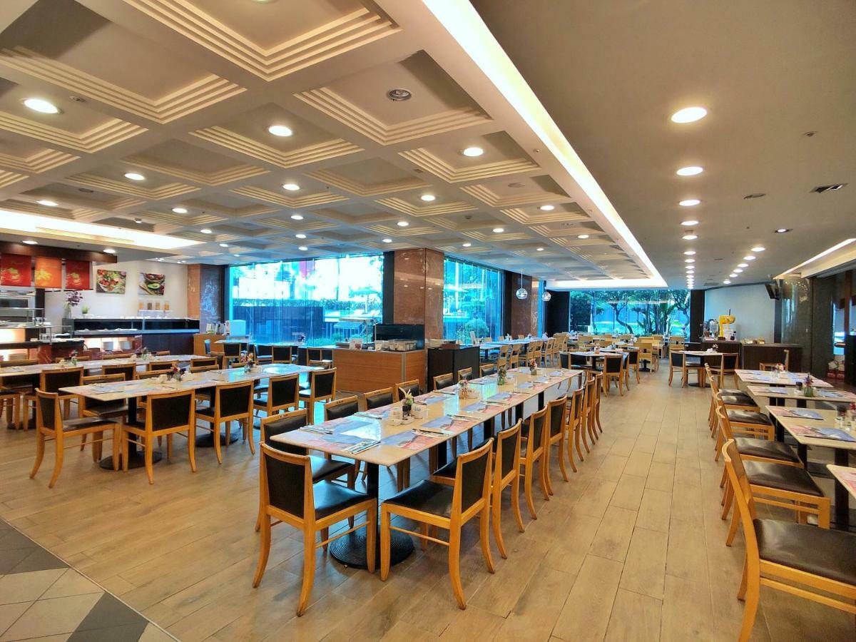 Evergreen Laurel Hotel - טאיצ'ונג מראה חיצוני תמונה The photo shows the interior of a restaurant. It features a spacious dining area with several wooden tables and chairs arranged in rows. The floor has a light wood finish, complementing the stylish design. The ceiling is decorated with a modern patte