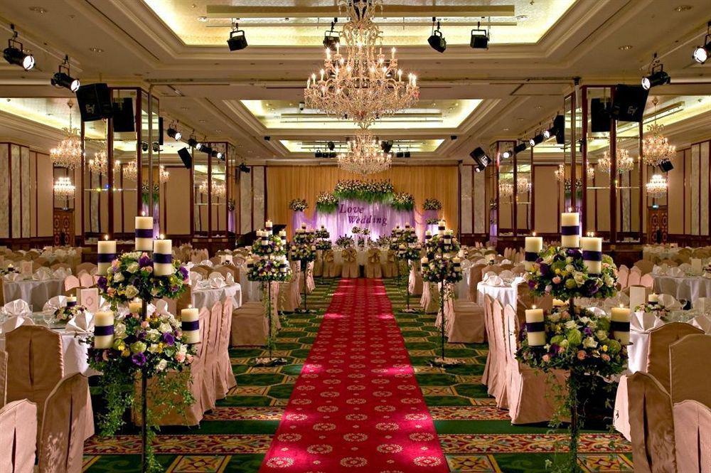 Evergreen Laurel Hotel - טאיצ'ונג מראה חיצוני תמונה The photo shows an elegantly decorated banquet hall set up for a wedding or formal event. The center aisle is lined with rows of elegantly draped chairs and features a bright red carpet. On either side of the aisle, there are beautifully arranged flo