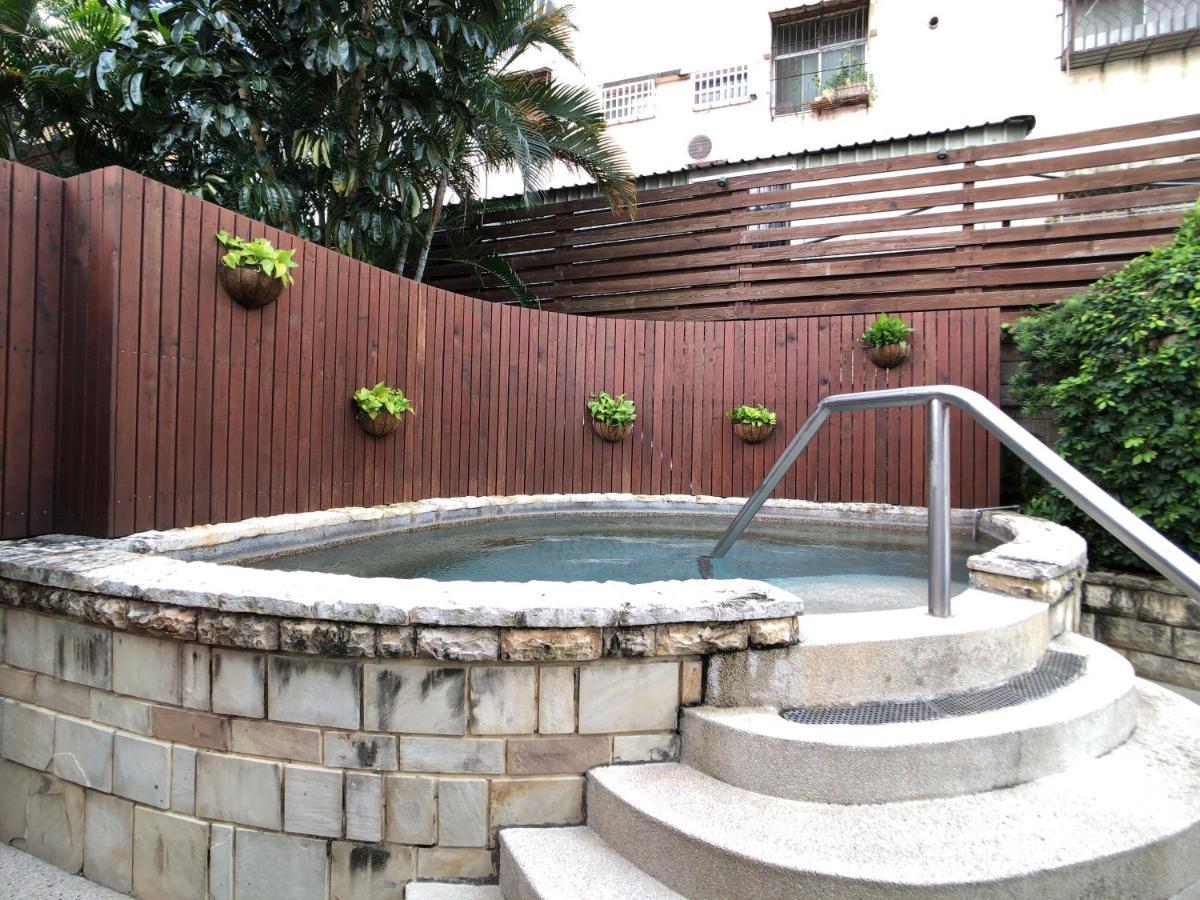 Evergreen Laurel Hotel - טאיצ'ונג מראה חיצוני תמונה The photo shows a small outdoor hot tub or spa area. It's surrounded by a wooden fence, with several planters containing greenery attached to the wall. The hot tub is round, with a stone border, and there are steps leading up to it with a stainless s
