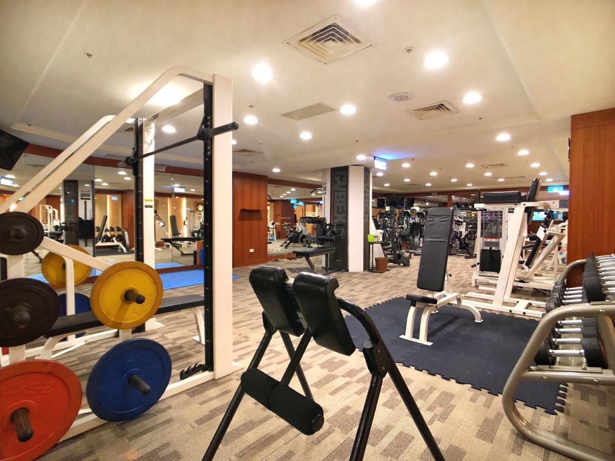 Evergreen Laurel Hotel - טאיצ'ונג מראה חיצוני תמונה The photo shows a gym interior with various workout equipment. On the left, there are weights of different colors stacked on a weight rack. In the foreground, there's a bench for exercises, and in the background, multiple machines for strength traini